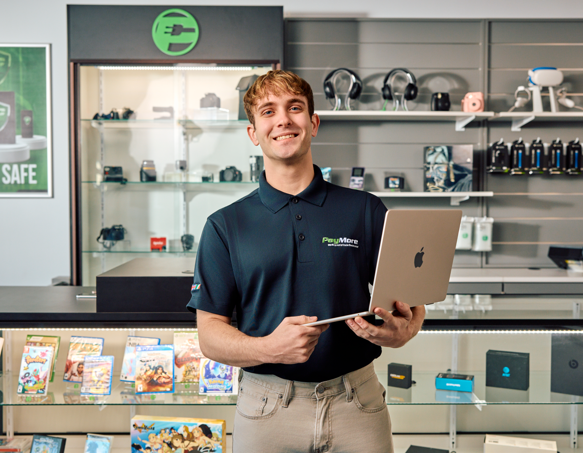 paymore employee holding a laptop and smiling